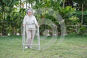 happy asian senior woman standing with walker in garden at home . old health care lifesyle photo