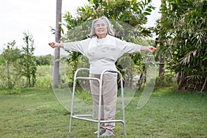 happy asian senior woman standing with walker in garden at home . old health care lifesyle photo