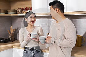 Happy asian spouses enjoying time together, drinking coffee