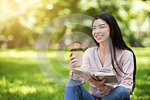 Happy Asian Student Girl Reading Book Outdoor In Park And Enjoying Coffee