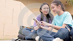 Happy Asian student girls using smart phone in school