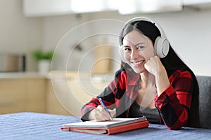 Happy asian student posing looking at camera in the kitchen