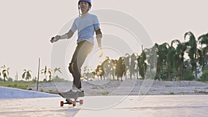 Happy Asian teen boy exercise surf skate at parking in her house