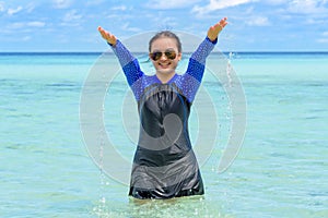 Happy asian teen girl play splashing water in the sea