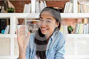 Happy asian teen girl student making video call to friend