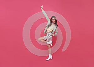 Happy Asian teen woman smiling and standing with hand up celebrating gesture on pink copy space background