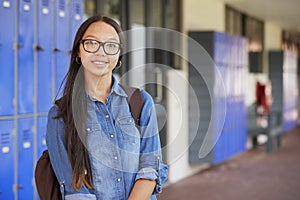 Happy Asian teenage girl smiling in high school corridor