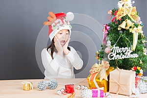 Happy asian thai child girl with Christmas gifts near a Christm