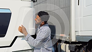 Happy asian truck driver loving his job. Indian trucker hugging his truck vehicle for transportation