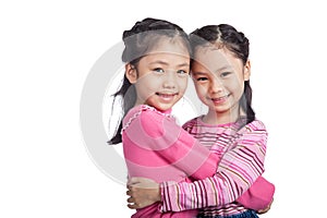 Happy Asian twin sisters hug each other