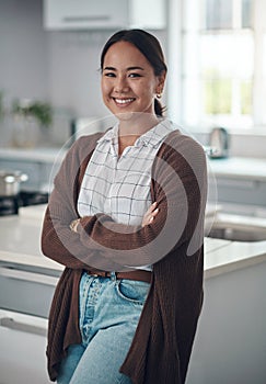 Happy, asian woman and arms crossed, thinking in portrait for cooking new recipe in kitchen. Happiness, female person