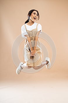 happy asian woman in casual clothes with poni tail jumping photo
