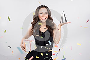 Happy asian woman celebrating holding gift box with confetti on