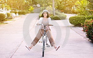 Happy asian woman cycling spreads legs on bicycle at park,Practice pedaling circles,Riding a bike