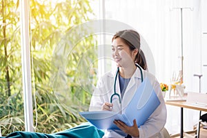 Happy asian woman doctor writing report with reassuring her female patient in hospital room,Doctor giving a consultation and encou