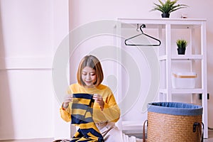 Happy asian woman doing laundry with basket at home