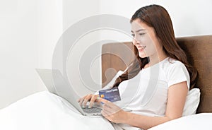 Happy asian woman doing online shopping at home, Women shopping online with credit card and laptop on the bed at home