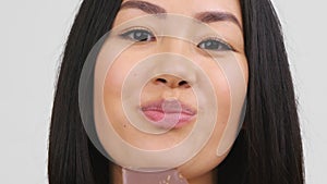 Happy Asian Woman Eating Chocolate Bar Posing Over White Background