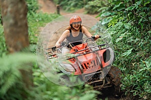 happy asian woman enjoy her atv trip through the difficult terrain