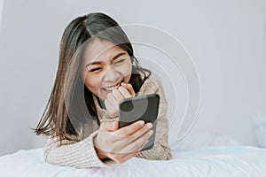 Happy Asian woman enjoy using smartphone