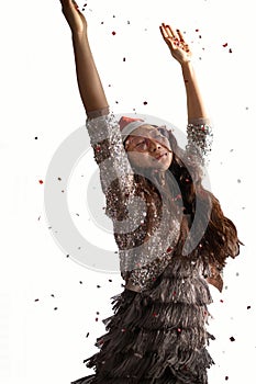 Happy asian woman at a festive party with confetti falling all over her. Christmas and New Year celebrating concept
