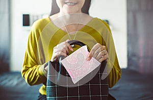 Happy asian woman hand putting sanitary napkin in handbag,White menstrual pad,Menses photo