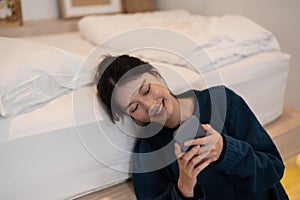 Happy asian woman hand using smartphone typing, chatting conversation in chat box on her bedroom, Social media maketing