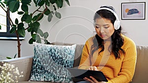 Happy asian woman in headphones listening to music