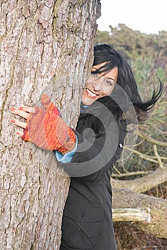 Happy Asian woman hugging a tree