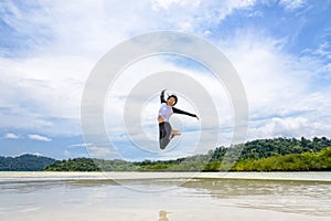 Happy asian woman jumping fun on the beach