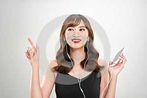 Happy asian Woman listening to music on headphones. Young fresh Asian female model