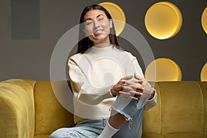 Happy asian woman looks into the camera and talks, holds a video call conference, an online interview at home sitting on