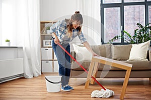 Happy asian woman with mop cleaning floor at home