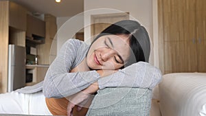 Happy asian woman napping while sitting on couch in living room,Comfortable sofa enjoying,Relaxing time