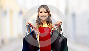 Happy asian woman with open shopping bags