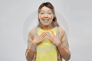 Happy asian woman over grey background