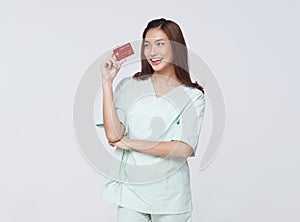 Happy asian woman patient showing credit card isolated on white background. Insurance allowance and charge indemnification concept photo