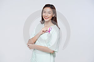 Happy asian woman patient showing pink badge ribbon chest to support breast cancer cause. breast cancer awareness concept