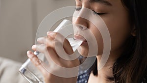 Happy asian woman quenching thirst drinking cool clear potable water