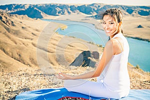 Happy asian woman relaxing and meditating above river valley
