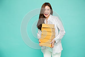Happy Asian woman smiling and holding package parcel box  on light green background.