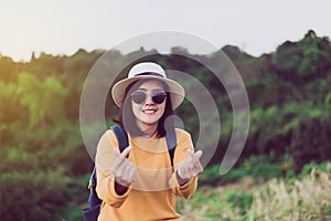 Happy asian woman standing and showing mini heart shape at sunset,Free time,Positive thinking