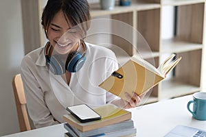 Happy asian woman student busy studying using laptop make notes in notebook, focused man worker employee write watching