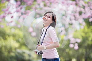 Happy asian woman tourist in spring blossom park walking and take a photo leisure activity