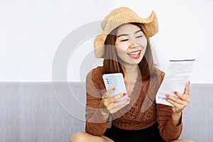 Happy Asian woman using smart phone scan QR code on electricity bill to pay online ,people with technology concept