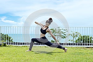Happy Asian woman wearing black sport wear relaxing in yoga High Lunge twist pose