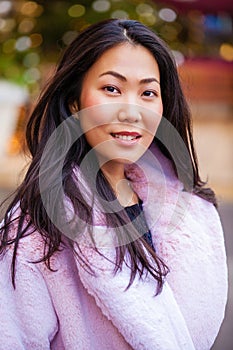 Happy asian woman in winter coat from faux fur