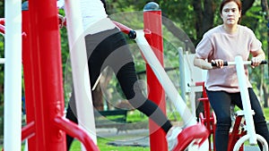 Happy asian women,mother and daughter enjoying,exercising with exercise machine in a public park,playing to good healthy,child gir