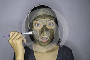 Happy Asian women smiling when she use brush to beauty face mask