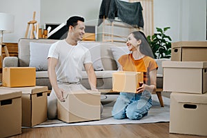 Happy asian young attractive couple man and woman with big boxes moving into a new house, new apartment for couple the new home,